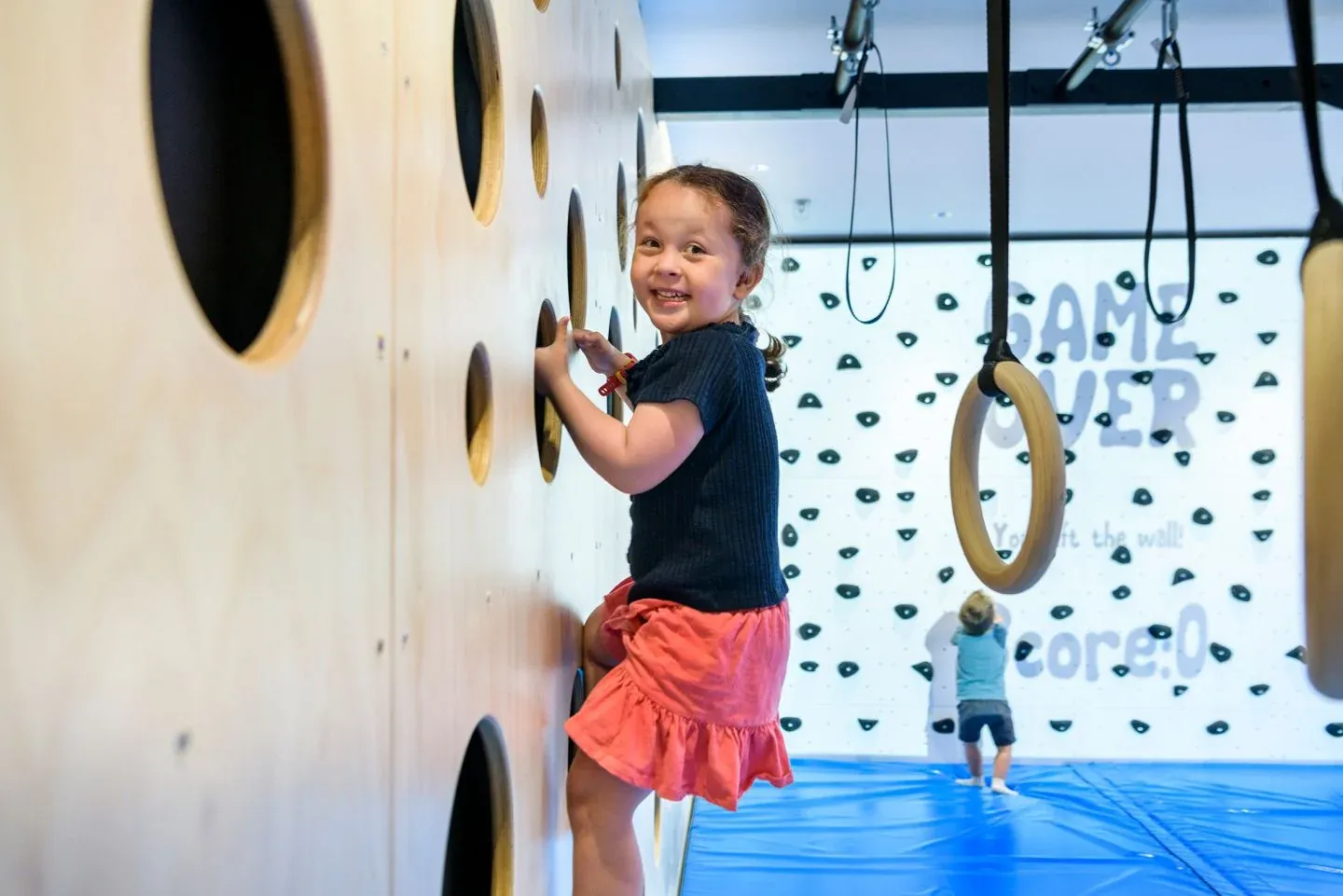 A child on an indoor climbing wall in photography from Brighter’s Can:Do 4Kids project