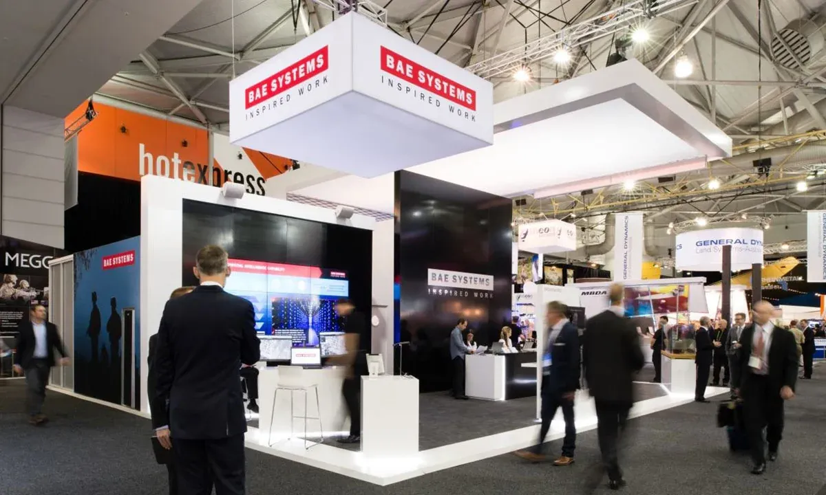 BAE Systems exhibition stand with branded overhead signage, screens and meeting spaces