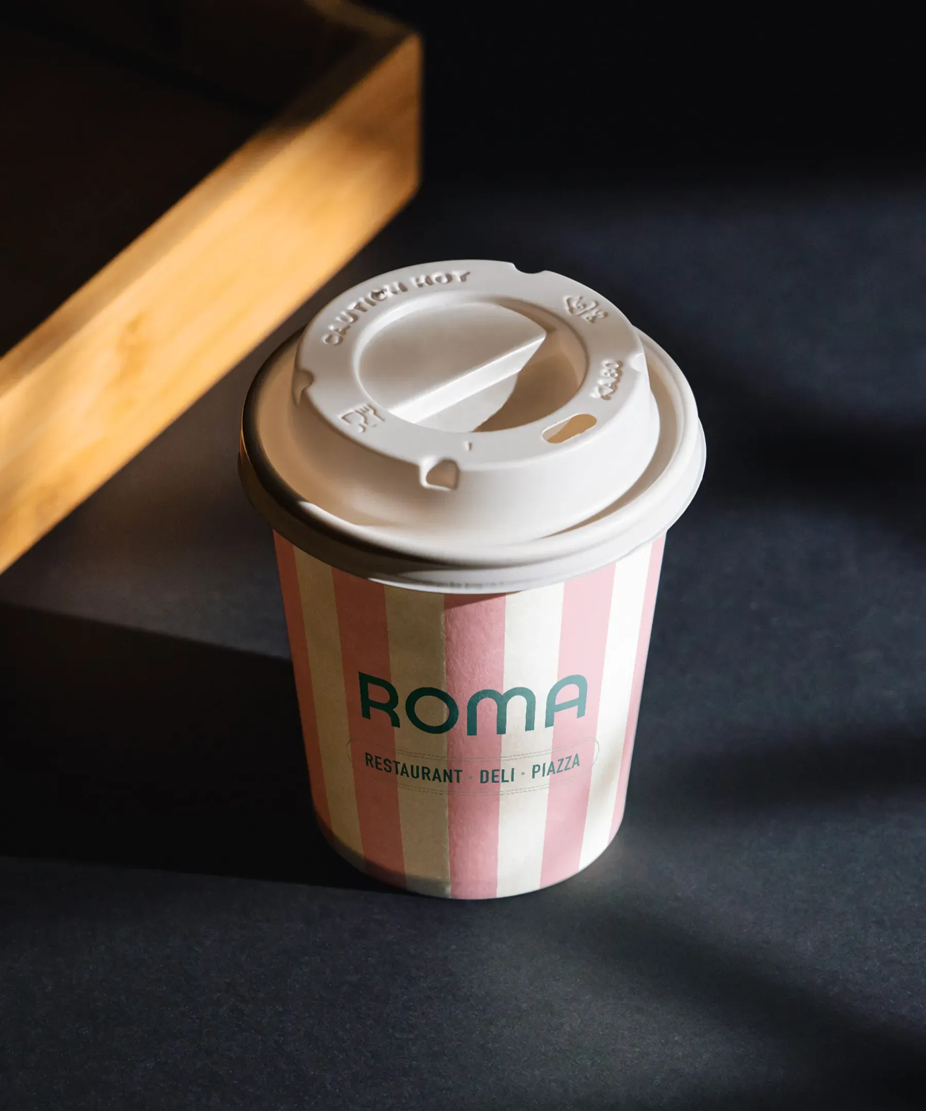 ROMA coffee cup carrying its restaurant identity